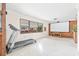 A spacious living room featuring large windows, projector screen, and light terrazzo flooring at 5821 52Nd N Ave, Kenneth City, FL 33709