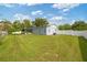 Backyard featuring lush green grass, well-maintained landscaping, and a screened patio at 602 Hillpoint Way, Brandon, FL 33510