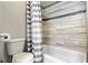 Cozy bathroom with a tile shower, patterned shower curtain and modern fixtures at 602 Hillpoint Way, Brandon, FL 33510