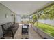 An inviting screened patio with wicker furniture overlooking a well-maintained backyard and lawn at 602 Hillpoint Way, Brandon, FL 33510