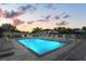 Twilight view of community pool showcasing tranquil setting with comfortable seating, ambient lighting, and modern design at 6206 64Th N Way, Pinellas Park, FL 33781