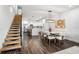 Open-concept layout integrating a modern kitchen with a dining area, complemented by sleek floating stairs at 6206 64Th N Way, Pinellas Park, FL 33781