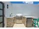 Modern outdoor kitchen featuring a stainless steel grill, sink, and stylish stone accents at 6206 64Th N Way, Pinellas Park, FL 33781