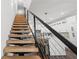 Modern staircase with wood treads and metal railings next to an open concept kitchen at 6206 64Th N Way, Pinellas Park, FL 33781