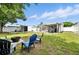 Spacious backyard featuring lush grass, a storage shed, and covered patio for outdoor living at 6212 S Adelia Ave, Tampa, FL 33616