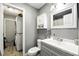 Bathroom includes a modern vanity, toilet, mirror and built-in storage, next to the laundry area at 6212 S Adelia Ave, Tampa, FL 33616