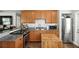 Well-equipped kitchen featuring granite counters, wood cabinets, tile backsplash, and modern appliances at 6212 S Adelia Ave, Tampa, FL 33616