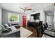Cozy living room featuring a modern ceiling fan, red front door, and comfortable seating arrangement at 6212 S Adelia Ave, Tampa, FL 33616