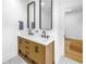 Bathroom featuring dual sinks, wood cabinets, tile floors, and modern fixtures at 650 63Rd S Ave, St Petersburg, FL 33705