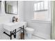 Modern bathroom featuring a floating sink, white tile walls, and decorative black fixtures at 650 63Rd S Ave, St Petersburg, FL 33705