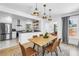 Dining room open to kitchen features pendant lights, seating, and large windows at 650 63Rd S Ave, St Petersburg, FL 33705