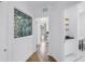 Hallway with hardwood flooring, a decorative glass window and bathroom access at 650 63Rd S Ave, St Petersburg, FL 33705