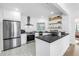 Modern kitchen features stainless steel appliances, white cabinets, and open shelving at 650 63Rd S Ave, St Petersburg, FL 33705