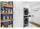 Well-appointed laundry room with stacked washer/dryer and custom storage shelving at 650 63Rd S Ave, St Petersburg, FL 33705