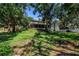 Spacious backyard showing the exterior of the house surrounded by mature trees at 6505 Cedar Ne St, St Petersburg, FL 33702