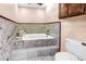 Bright bathroom featuring a tiled tub with grab bar and wall-mounted cabinets at 6505 Cedar Ne St, St Petersburg, FL 33702