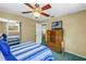 Bright bedroom with striped bedding, vintage furniture, and a ceiling fan at 6505 Cedar Ne St, St Petersburg, FL 33702
