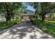 Two story home with a long driveway and front facing garage surrounded by large trees at 6505 Cedar Ne St, St Petersburg, FL 33702
