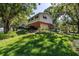 Brick and white two-story home with lush landscaping and a 2-car garage nestled among mature trees at 6505 Cedar Ne St, St Petersburg, FL 33702