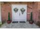 Double front doors accented with wreaths and potted topiaries in front of a brick facade at 6505 Cedar Ne St, St Petersburg, FL 33702