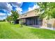 Exterior view of the home's screened-in porch and manicured backyard at 7077 Woodchase Glen Dr, Riverview, FL 33578