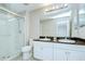 Bathroom featuring double sinks, white cabinets, granite countertop, and a glass enclosed shower at 7077 Woodchase Glen Dr, Riverview, FL 33578