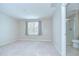Spacious bedroom featuring a large window, neutral walls, and an en-suite bathroom at 7077 Woodchase Glen Dr, Riverview, FL 33578