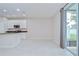 Bright dining room with an adjacent modern kitchen, featuring tile floors and sliding glass doors at 7077 Woodchase Glen Dr, Riverview, FL 33578