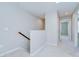 Hallway with neutral paint, a wooden stair rail, and access to multiple rooms at 7077 Woodchase Glen Dr, Riverview, FL 33578