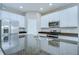 Updated kitchen featuring white cabinetry, granite countertops, and stainless appliances at 7077 Woodchase Glen Dr, Riverview, FL 33578