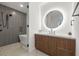 Modern bathroom featuring a round illuminated mirror, sleek vanity, and walk-in shower with stylish gray tiling at 777 3Rd N Ave # 1406, St Petersburg, FL 33701