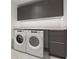 Well-organized laundry area with front-load washer, dryer, and overhead storage at 777 3Rd N Ave # 1406, St Petersburg, FL 33701