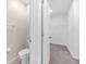 Bathroom with a toilet and doorway leading to a carpeted walk-in closet with wire shelving at 797 Olive Conch St, Ruskin, FL 33570