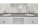 Bathroom vanity featuring double sinks, granite countertops, framed mirrors, and ample lighting at 797 Olive Conch St, Ruskin, FL 33570
