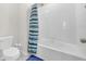 Tiled bathroom with shower and tub, shower curtain, toilet, and ample lighting at 797 Olive Conch St, Ruskin, FL 33570