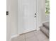 Clean entryway featuring a white front door, tile flooring, and carpeted stairs at 797 Olive Conch St, Ruskin, FL 33570