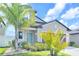 Charming home featuring a welcoming blue front door and lush tropical landscaping at 797 Olive Conch St, Ruskin, FL 33570