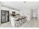 Bright kitchen with modern black appliances, granite counters, and a large island with bar seating for four at 797 Olive Conch St, Ruskin, FL 33570