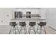 Bright kitchen with modern black appliances, granite counters, and a large island with bar seating for four at 797 Olive Conch St, Ruskin, FL 33570