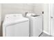 Laundry room with a white washer and dryer plus wire shelving for convenient storage at 797 Olive Conch St, Ruskin, FL 33570