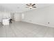 Open-concept living room with tile floors, a ceiling fan, and a view into the kitchen with barstool seating at 797 Olive Conch St, Ruskin, FL 33570