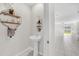 Stylish powder room with decorative shelving and an open view of the living area at 797 Olive Conch St, Ruskin, FL 33570