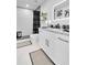 Modern bathroom features a walk-in shower, floating shelves, and sleek black and white accents at 8010 W Hiawatha St, Tampa, FL 33615