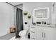 Modern bathroom featuring tiled shower, vanity with granite countertop, and illuminated mirror at 8010 W Hiawatha St, Tampa, FL 33615