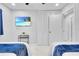 Bright bedroom with dual beds, closet, and TV showing a beach for a relaxing ambiance at 8010 W Hiawatha St, Tampa, FL 33615