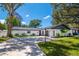 Charming single-story home with a circular driveway, manicured lawn, and lush landscaping at 8010 W Hiawatha St, Tampa, FL 33615