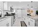 Stylish kitchen with white cabinetry, stainless steel appliances, and a sliding barn door at 8010 W Hiawatha St, Tampa, FL 33615