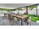 Inviting covered patio boasts an outdoor dining area, lounge seating, and views of the backyard at 8010 W Hiawatha St, Tampa, FL 33615