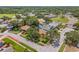 A sunny aerial view of a neighborhood showcases a charming single-Gathering home with mature landscaping at 8405 Woodbridge Blvd, Tampa, FL 33615