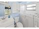Bright bathroom with a white vanity, toilet, and a walk-in tub near a window at 8405 Woodbridge Blvd, Tampa, FL 33615